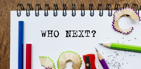 who next text written on a paper with pencils in officeの写真素材