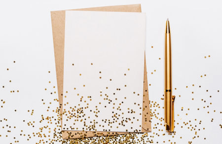 Blank note with envelope, pen and gold glitter stars on white backgroundの写真素材
