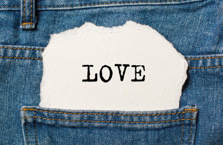 love on torn paper background on jeans love and valentine conceptの写真素材