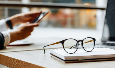 Glasses at the workplace in the office near the laptop and notepad. Business hoursの写真素材