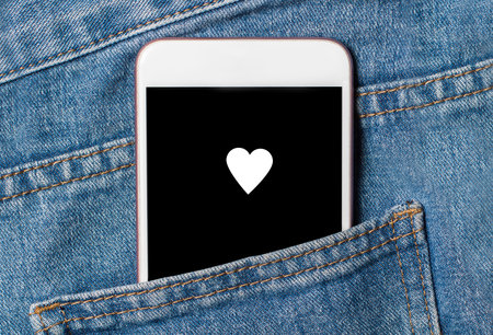 heart on background phone on jeans love and valentine conceptの写真素材