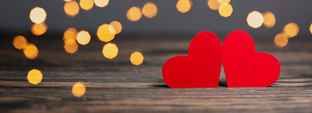 pair of red hearts on lights background, love and valentine concept on a wooden tableの写真素材