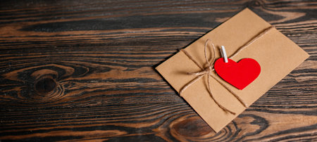 Love letter with a heart on a background of lights, love and valentine concept on a wooden tableの写真素材