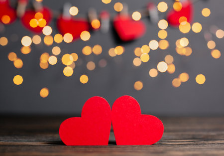 pair of red hearts on lights background, love and valentine concept on a wooden tableの写真素材