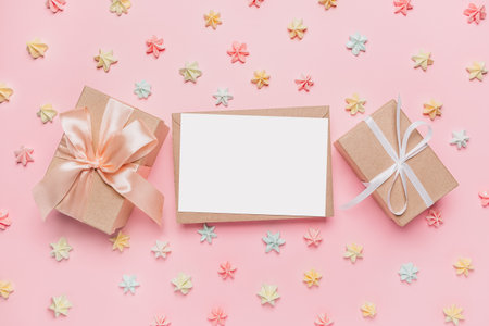 Gifts with note letter on isolated pink background with sweets, love and valentine conceptの写真素材