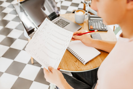 Business man checks information in charts in office near laptopの写真素材