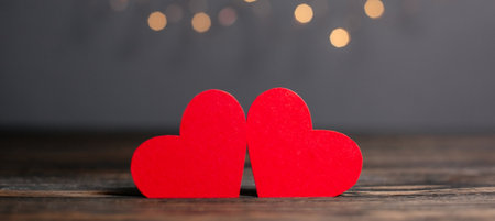 pair of red hearts on lights background, love and valentine concept on a wooden tableの写真素材
