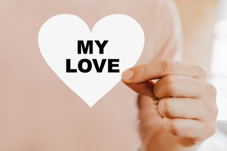 Man holding a love card in the shape of a heart with my loveの写真素材