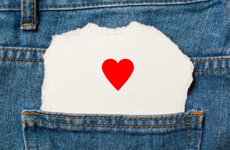 heart on torn paper background on jeans love and valentine conceptの写真素材