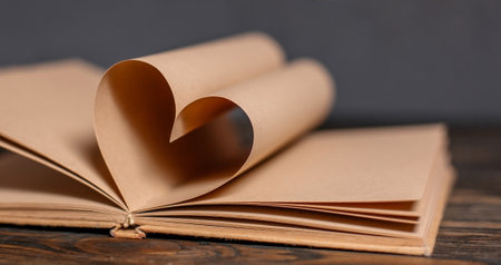 Heart made from book sheets, love and valentine concept on a wooden tableの写真素材
