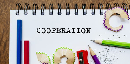 COOPERATION text written on a paper with pencils in officeの写真素材