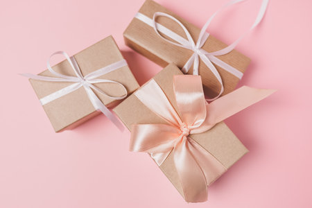 Gifts with wihte ribbon on isolated pink background, love and valentine conceptの写真素材