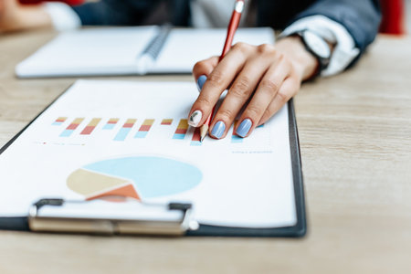 Business woman checks charts and refreshes financial progress. The girl analyzes the business model in the workplace.の写真素材