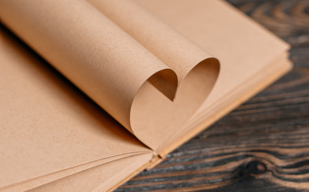 Heart made from book sheets, love and valentine concept on a wooden tableの写真素材
