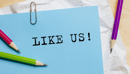 Like us text written on a paper with pencils in officeの写真素材