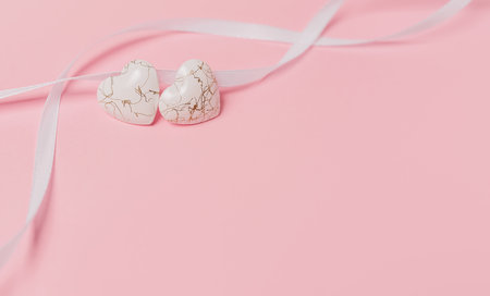 shape heart with wihte ribbon on isolated pink backgroundの写真素材