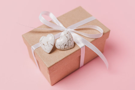 Gift with wihte hearts on isolated pink background, love and valentine conceptの写真素材