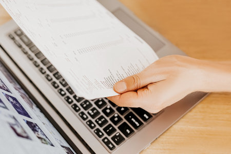 Business man checks information in charts in office near laptopの写真素材