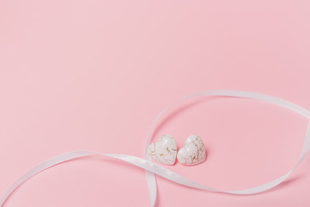 shape heart with wihte ribbon on isolated pink backgroundの写真素材