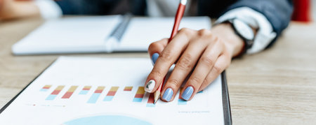 Business woman checks charts and refreshes financial progress. The girl analyzes the business model in the workplace.の写真素材