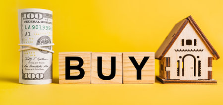 BUY with house miniature model and money on a yellow background. Investment, real estate, home, housing, earnings, financial conceptの写真素材