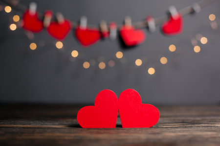 pair of red hearts on lights background, love and valentine concept on a wooden tableの写真素材