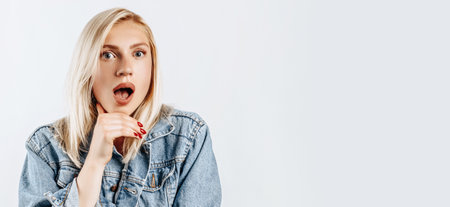 Beautiful young girl is surprised on gray isolated backgroundの写真素材