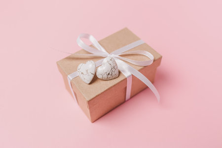 Gift with wihte hearts on isolated pink background, love and valentine conceptの写真素材