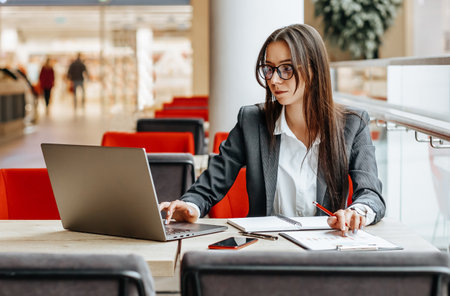 Girl works on a laptop in the workplace. Successful business woman creates a startup and makes decisions.の写真素材