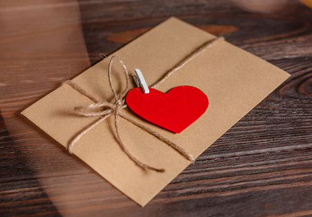 Love letter with a heart on a background of lights, love and valentine concept on a wooden tableの写真素材