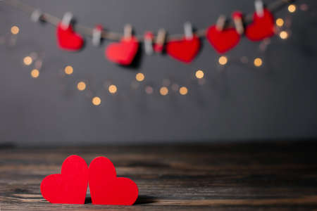 pair of red hearts on lights background, love and valentine concept on a wooden tableの写真素材