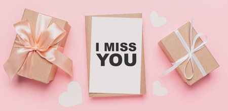 Gifts with note letter on isolated pink background, love and valentine concept with text I miss youの写真素材