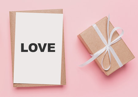 Gifts with note letter on isolated pink background, love and valentine concept with text loveの写真素材