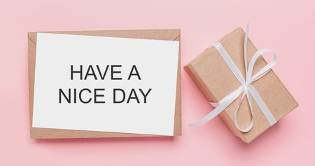 Gifts with note letter on isolated pink background, love and valentine concept with text HAVE A NICE DAYの写真素材