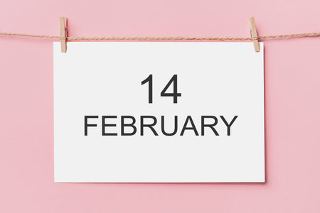 note letter pin on rope on pink background, love and valentine concept with text 14 februaryの写真素材