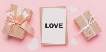 Gifts with note letter on isolated pink background, love and valentine concept with text loveの写真素材