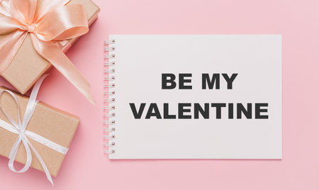 Gifts with note letter on isolated pink background, love and valentine concept with text be my Valentineの写真素材