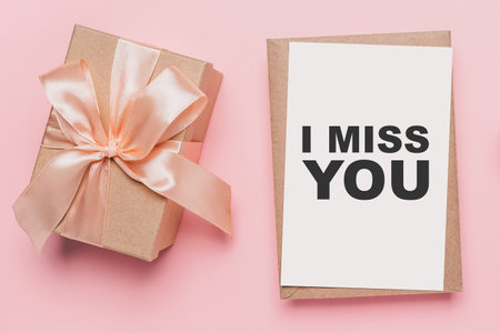 Gifts with note letter on isolated pink background, love and valentine concept with text I miss youの写真素材