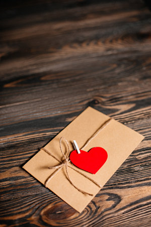 Love letter with a heart on a background of lights, love and valentine concept on a wooden tableの写真素材