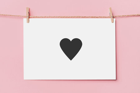 note letter pin on rope on pink background, love and valentine concept with heartの写真素材