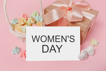Gifts with note letter on isolated pink background with sweets, love and valentine concept with text Womens Dayの写真素材