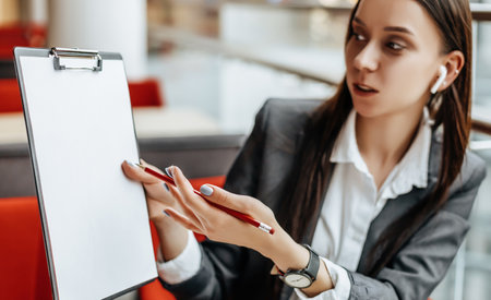Girl works on a laptop in the workplace. Businesswoman shows and explains the goals and objectives for the business. Successful woman creates a startup and makes decisions.の写真素材