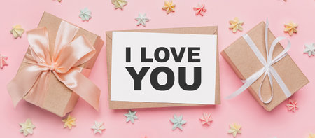 Gifts with note letter on isolated pink background with sweets, love and valentine concept with text I love youの写真素材