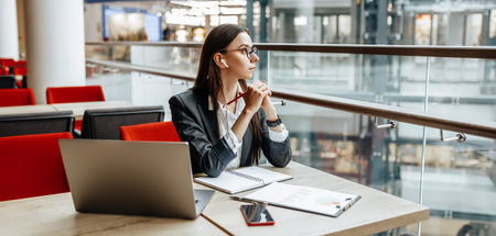 Girl works on a laptop in the workplace. Successful business woman creates a startup and makes decisions.の写真素材