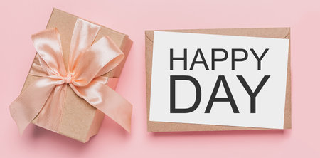 Gifts with note letter on isolated pink background, love and valentine concept with text happy dayの写真素材