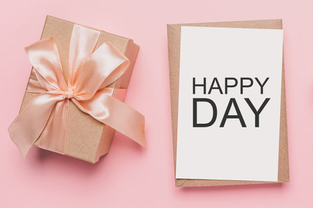 Gifts with note letter on isolated pink background, love and valentine concept with text happy dayの写真素材