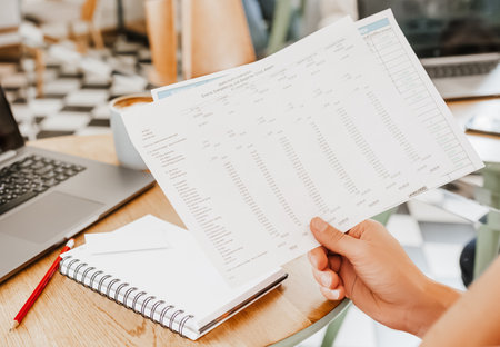 Business man checks information in charts in office near laptopの写真素材