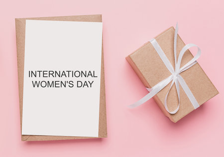 Gifts with note letter on isolated pink background, love and valentine concept with text International Womens Dayの写真素材