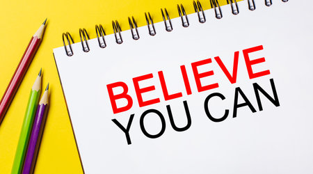 Believe you can on a white notepad with pencils on a yellow background. Business conceptの写真素材