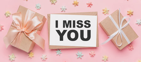 Gifts with note letter on isolated pink background with sweets, love and valentine concept with text I miss youの写真素材